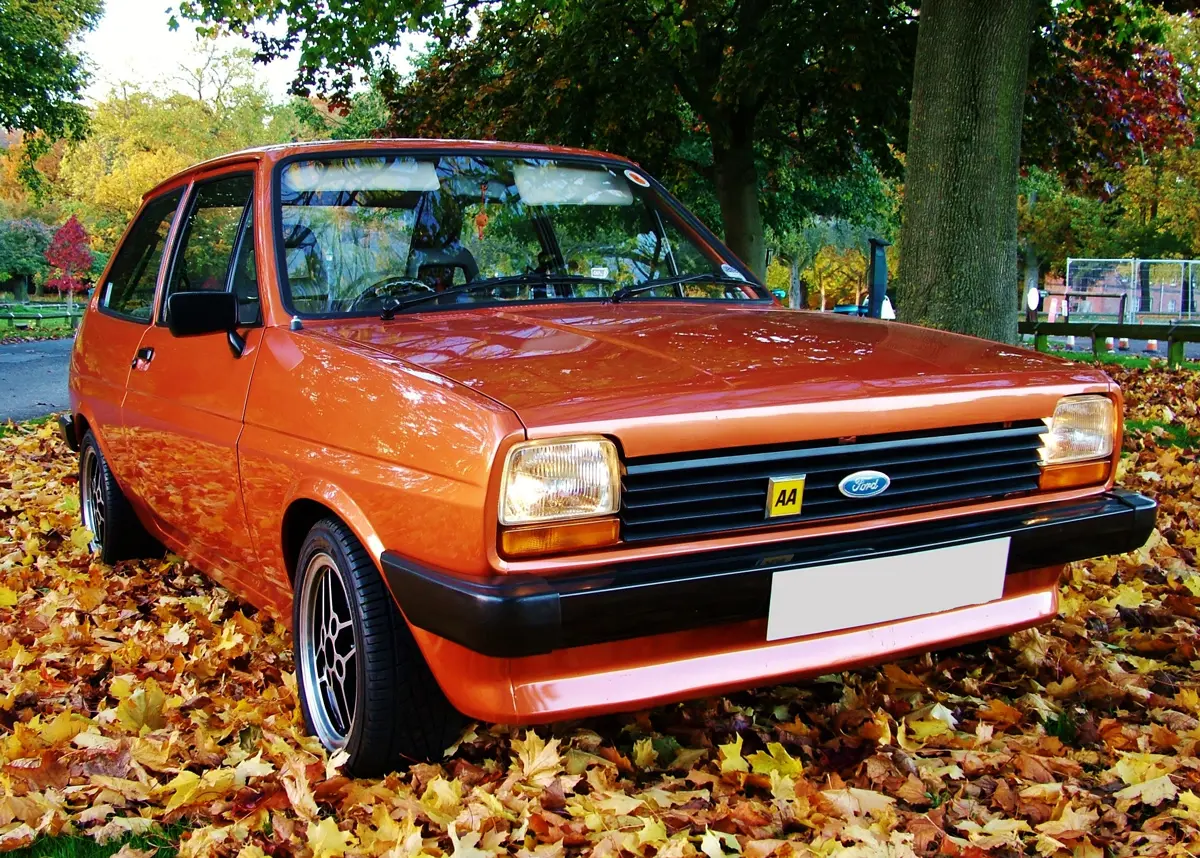 A bronze MK 2 Ford Fiesta parked over a pile of fallen brown leaves