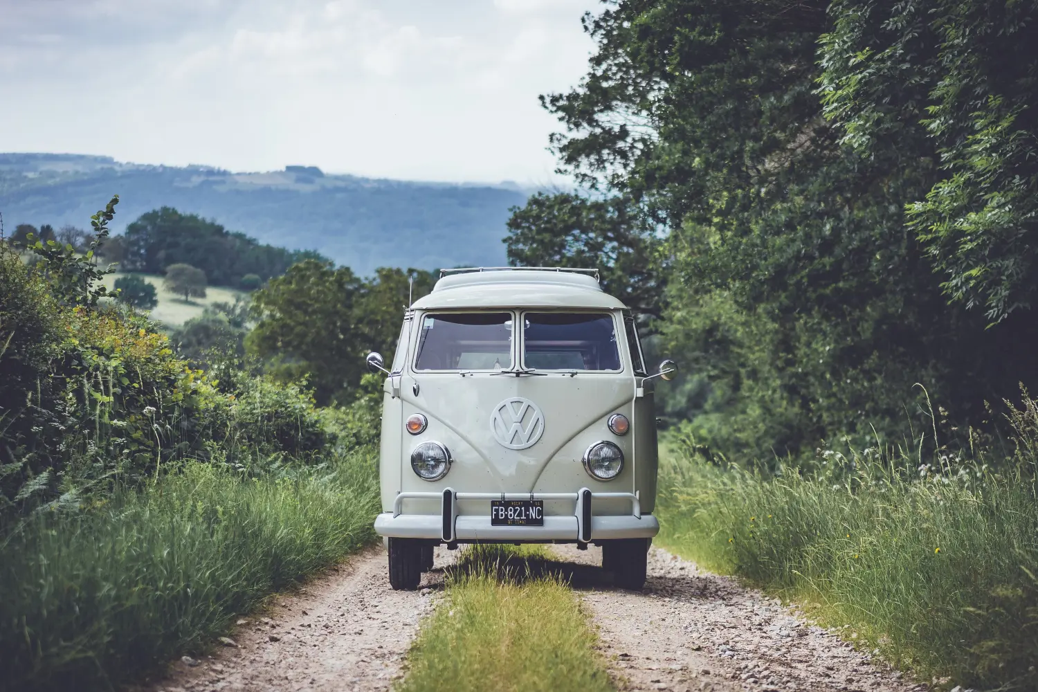 light green vw campervan parked on a country lane