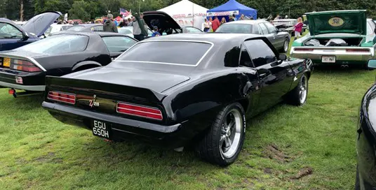 Black classic American muscle car parked at show