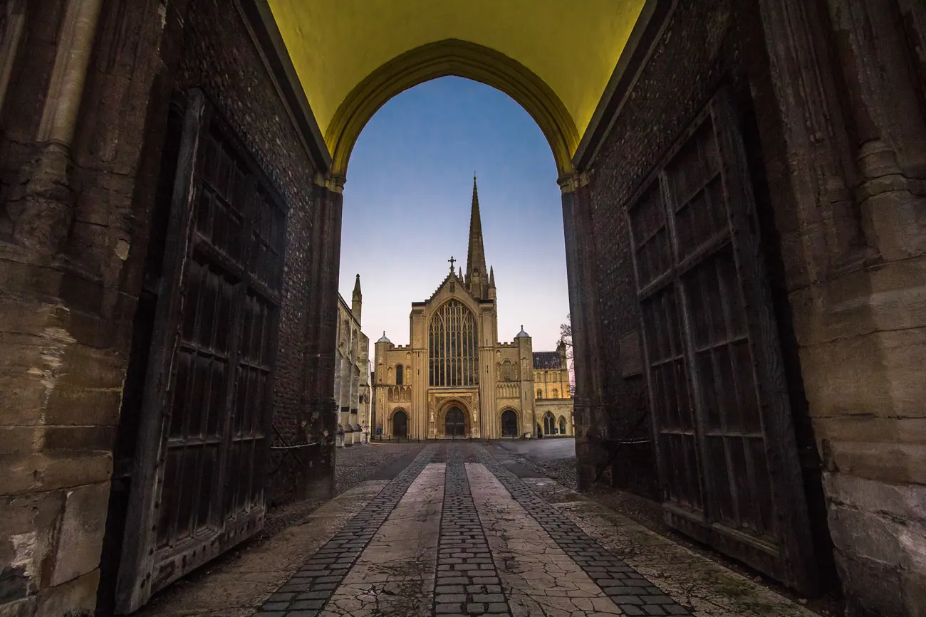 A large gothic cathedral seen through an arch with open wooden doors