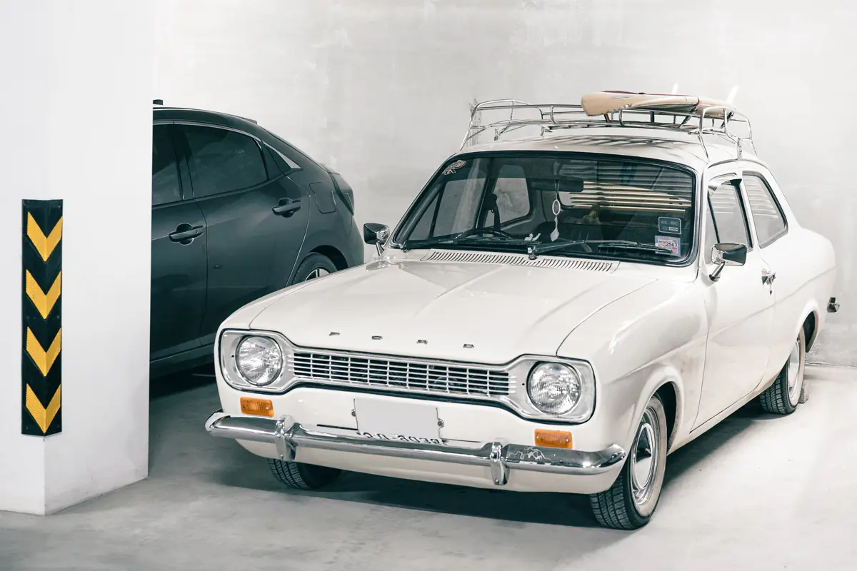 A white MK1 Ford Escort parked in an underground carpark