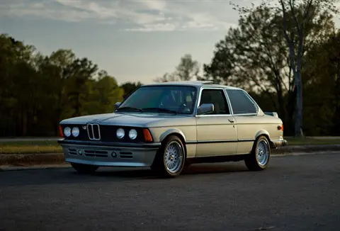 Gray BMW-E30 classic parked at sunset