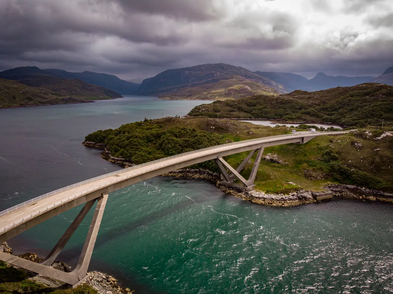 A long bridge over a blue river in a highland landscape