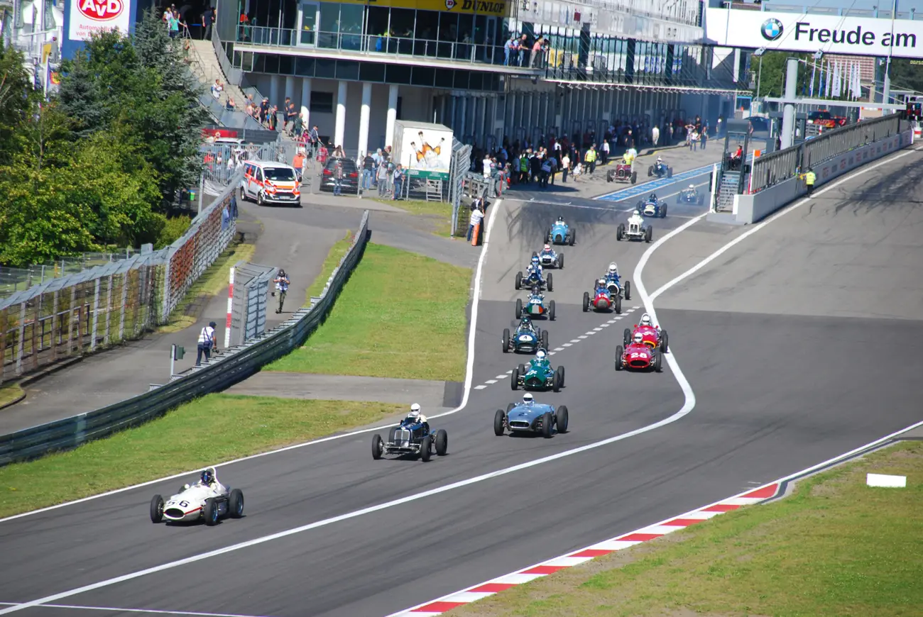 Classic formula 1 cars leaving the pit lane on a race track