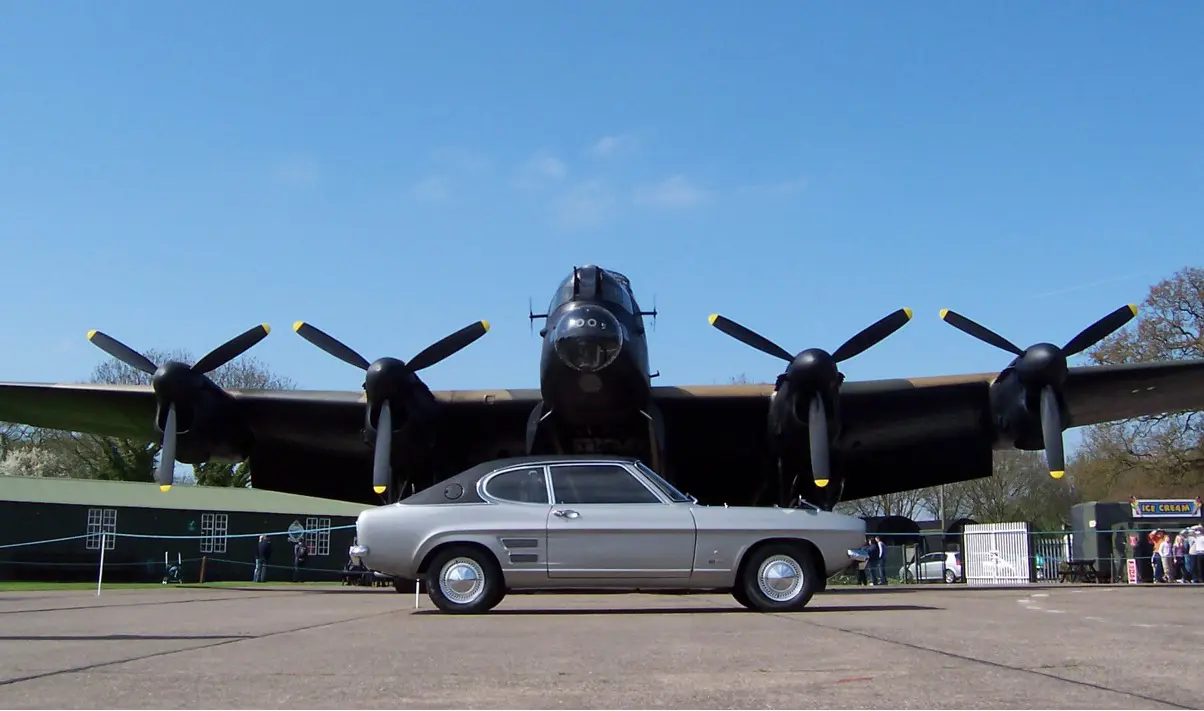 A Ford Capri parked in-front of a Lancaster bomber plane