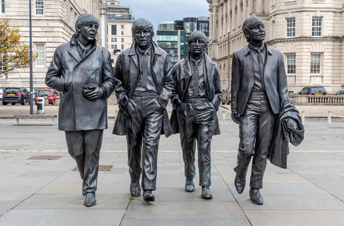 A statue of the Beatles walking on a street in Liverpool