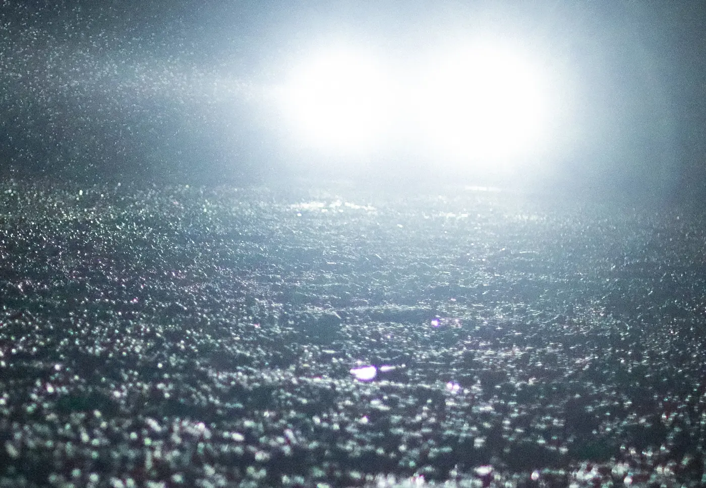 Bright headlights on a rainy road at night