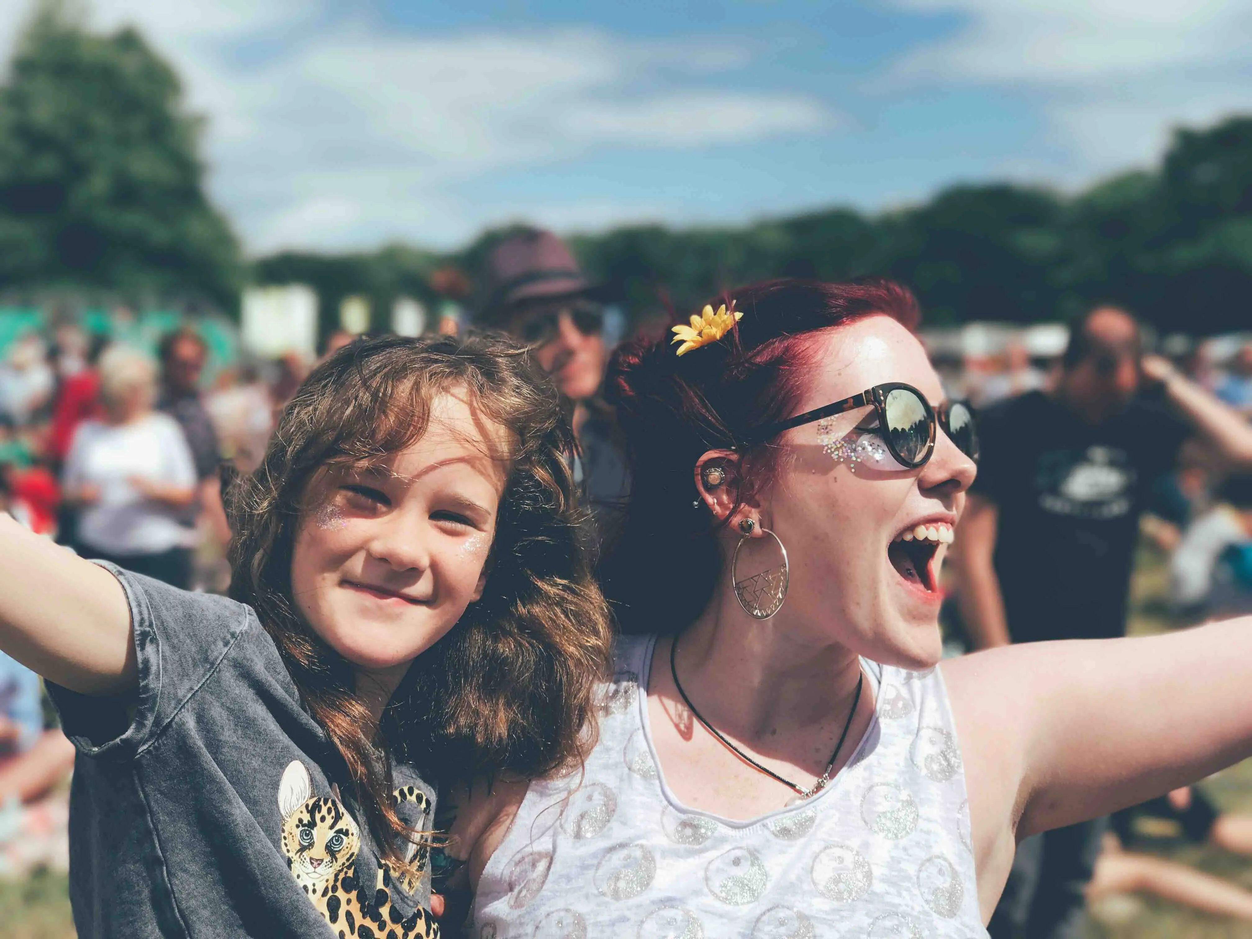 A mother and daughter dancing and singing together at a music festival