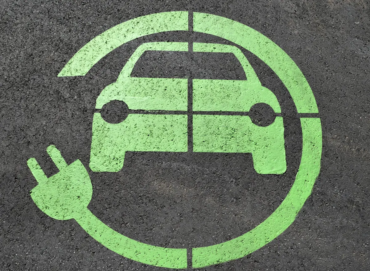 An electric car charging sign painted on tarmac