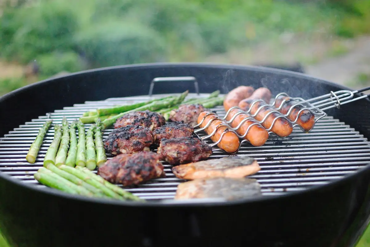 A barbeque with meat and veg grilling