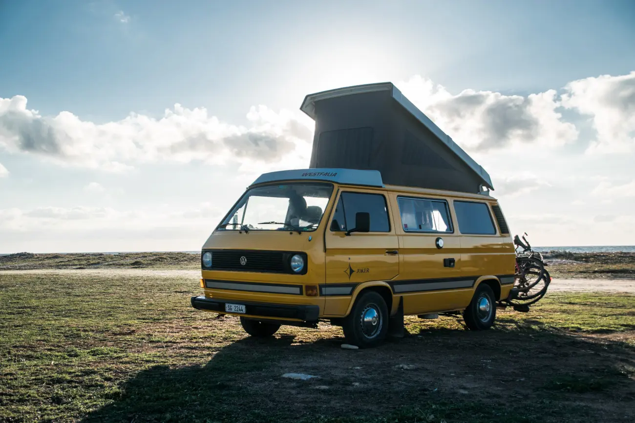 campervan parked on the grass with its roof raised