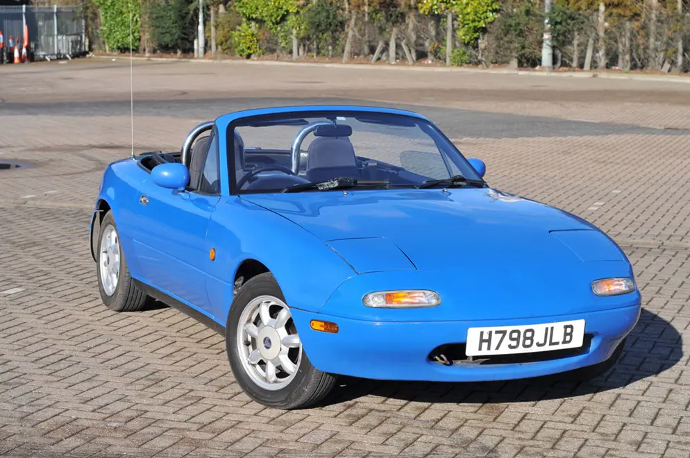 The Lancaster Insurance Eunos MX5 with its roof down in a car park