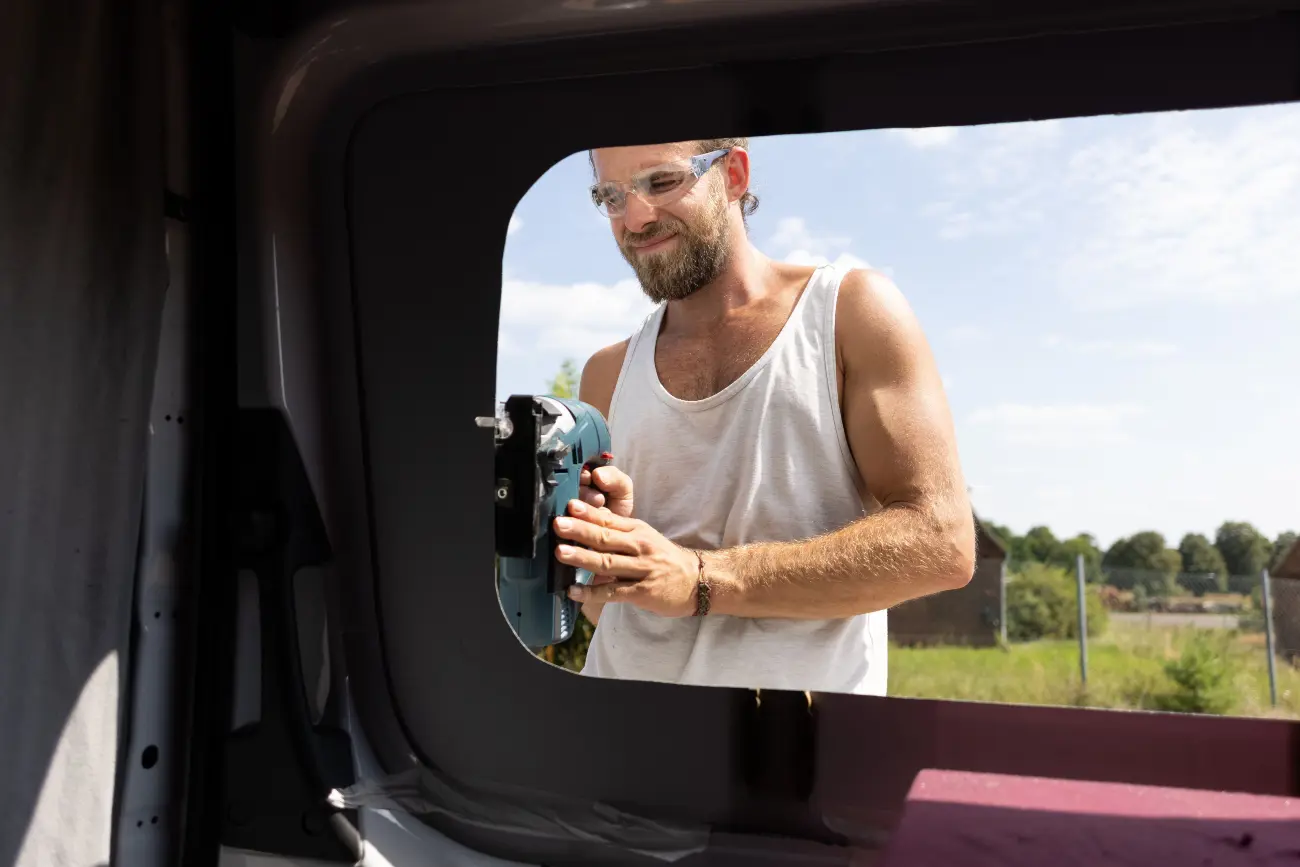 man filing window on campervan