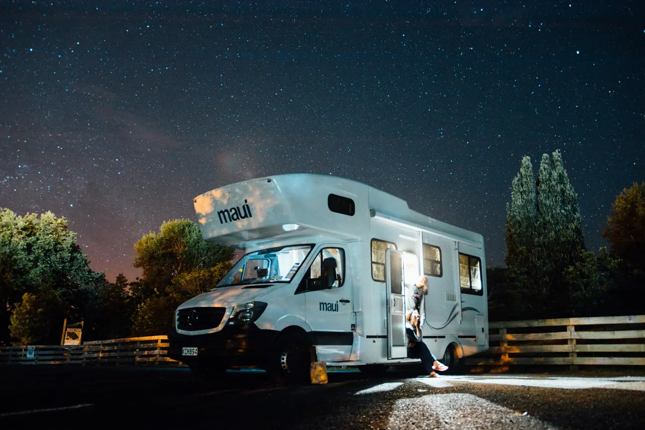 A motorhome parked at a campsite under a starry sky