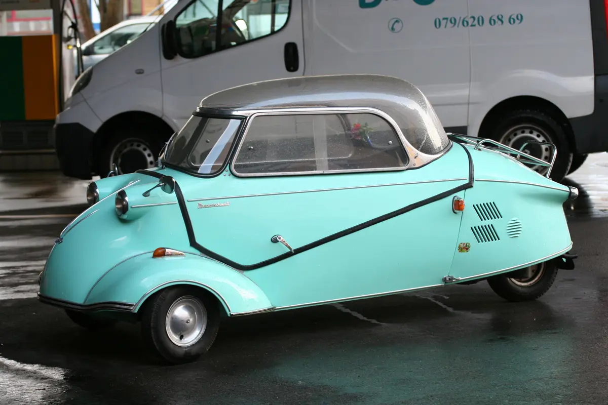 A blue Messershmitt KR200 parked in a car park on a wet day