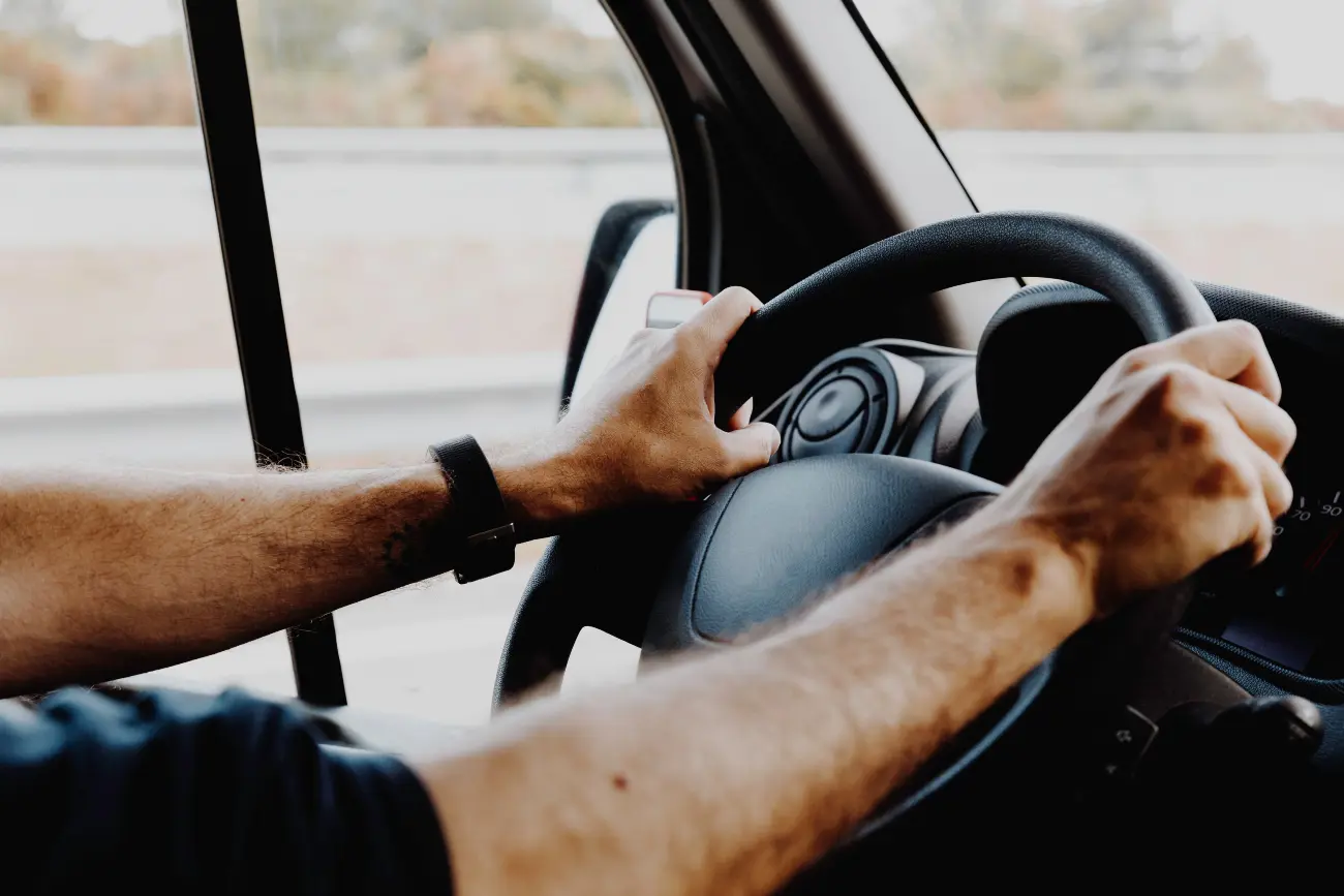A man holding the steering wheel while driving
