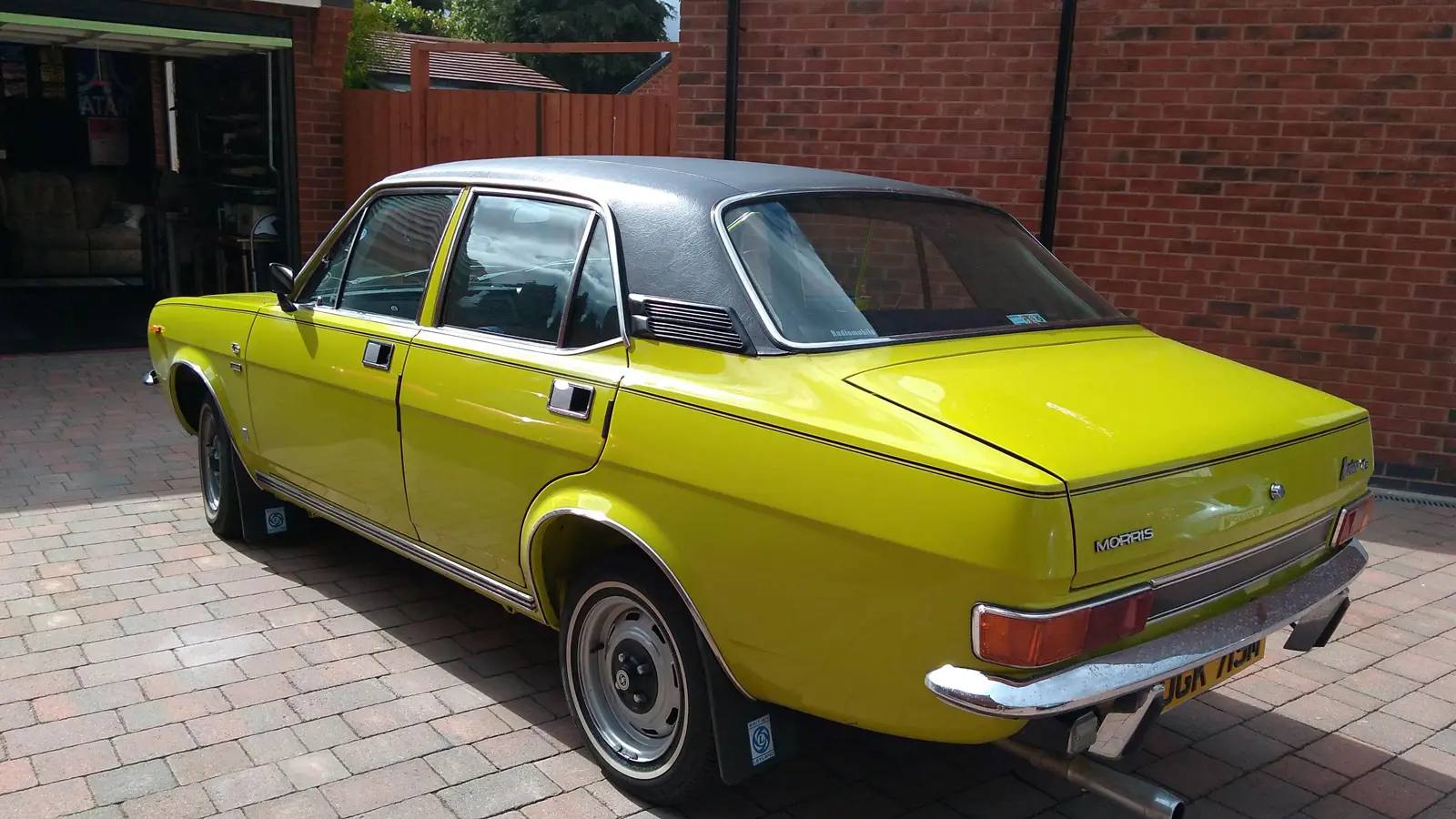 A rear view of the Morris on a brick driveway on a sunny day