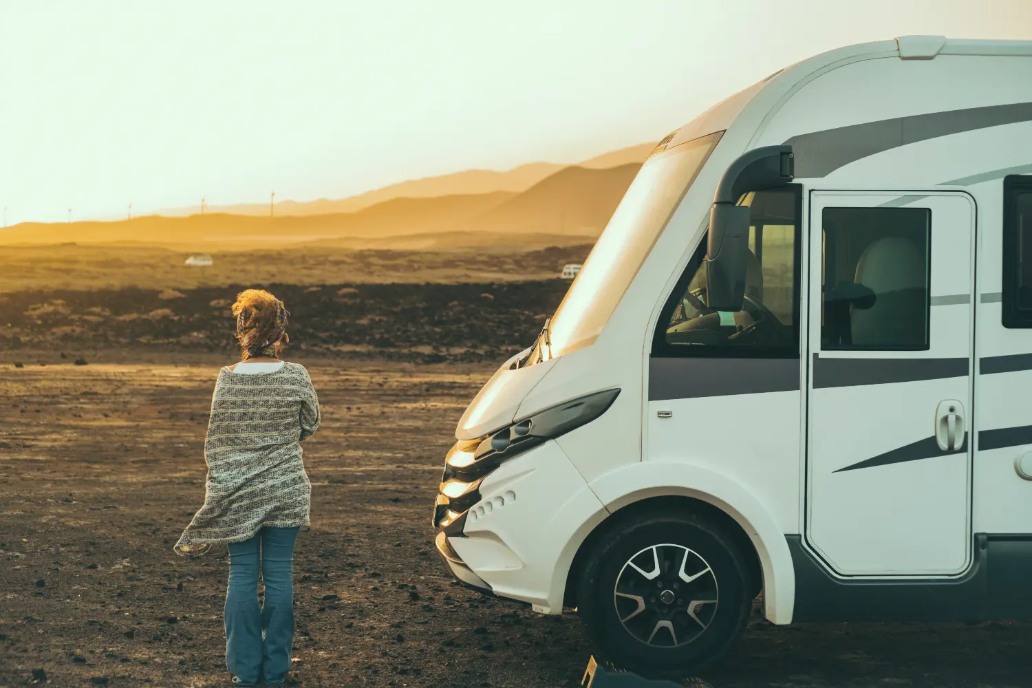 woman standing next to a campervan in the field