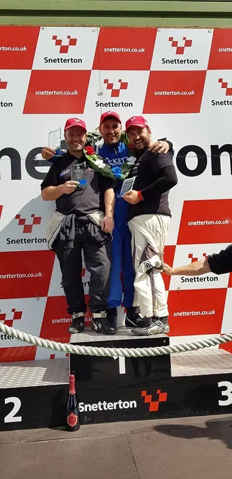 Alex on the podium embracing Wayne and another competitor