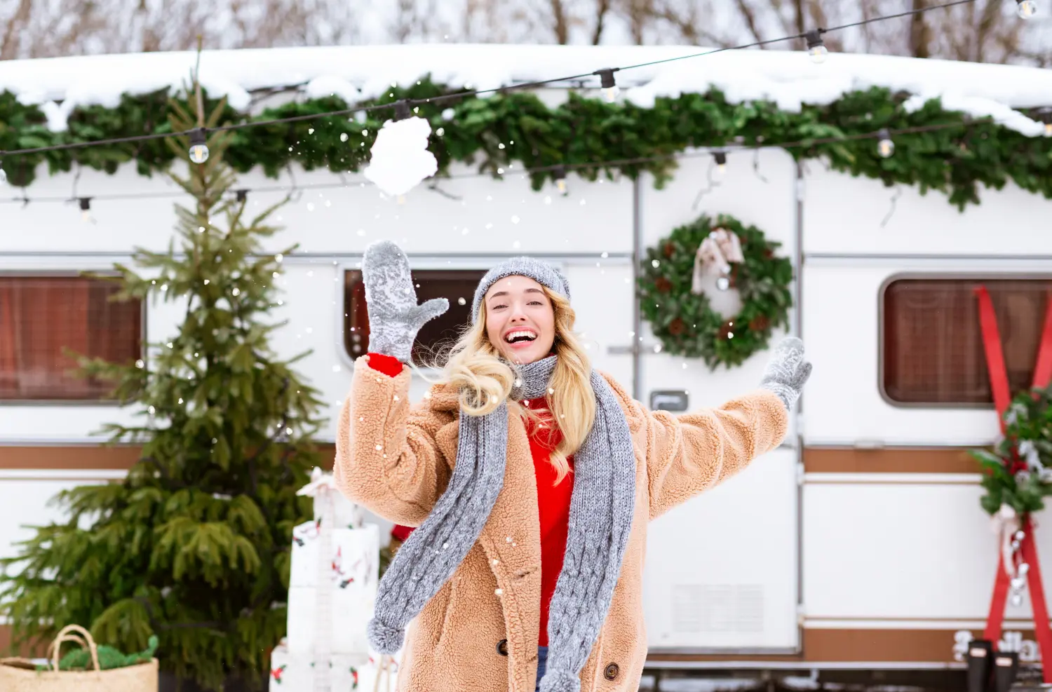 woman in warm clothing outside of christmassy camoervan