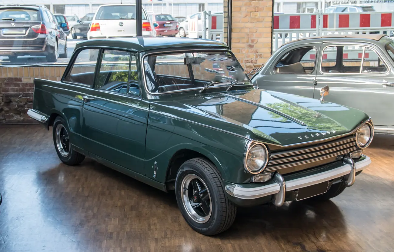 A clean Triumph Herald classic car in an auction showroom